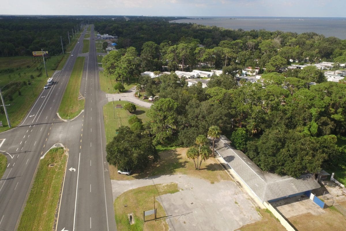 aerial view of highway with trees and buildings nearby